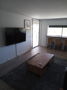 玛志洛马卢奇金沙假日公寓酒店的客厅配有咖啡桌和平面电视。