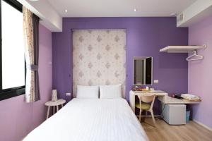 安平区哇哈哈食乐宅的一间卧室配有一张床和紫色的墙壁
