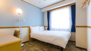 名古屋Toyoko Inn Nagoya Sakae的小房间设有床和窗户