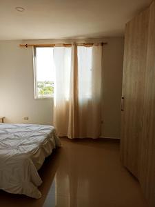 里奥阿查Hermoso apartamento frente al mar的一间卧室设有一张床和一个窗口