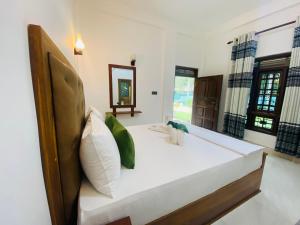 丹不拉完美藏身之地旅馆的卧室配有一张白色大床