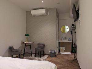 东京MARUKOU HOTEL的一间卧室配有一张床、一张桌子和空调