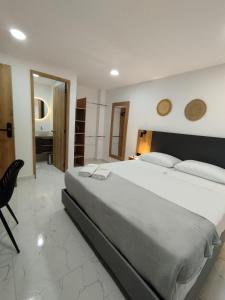 麦德林Zamá Room Hotel的卧室配有一张白色大床和一把椅子
