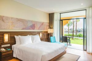 会安Hoi An Memories Resort & Spa的酒店客房设有一张床和一个阳台。