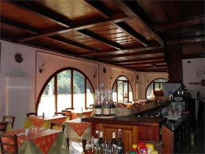 奥瓦达贝拉焦酒店的餐厅内的酒吧配有桌椅