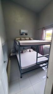 圣胡安Hidden Palms Inn/Resort La Union的小型客房设有两张双层床和窗户。