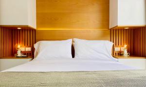 波哥大Charming loft in the heart of Santa Barbara的一张大床,配有两个白色枕头和两盏灯