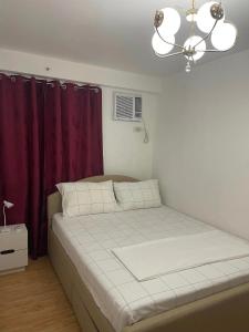 达沃市Arezzo Place Davao Condominium的紫色窗帘的房间的一张床位
