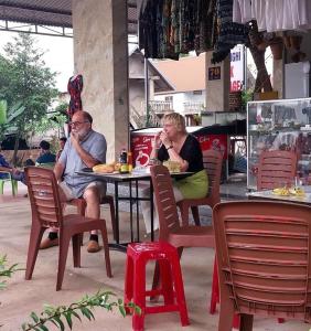 Lien SonLak village的坐在餐厅桌子上的男女