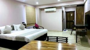阿南德HOTEL RADHE Anand的酒店客房配有一张床铺和一张桌子。