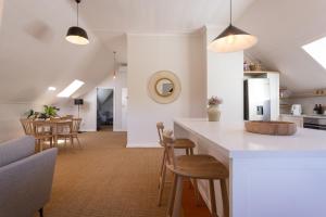 斯泰伦博斯Rozendal Stay的厨房以及带柜台和椅子的客厅。
