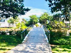 Xuyên MộcBiệt thự 5PN Resort Sanctuary HỒ Tràm ll Bãi biển riêng ll hồ bơi BBQ的公园里人行道上的桥梁