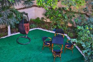 亚历山大Egyptus Villa Hostel的绿色草坪上摆放了两把椅子和一张桌子