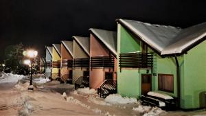 利普托斯基米库拉斯Tatralandia Apartmán的夜雪覆盖的房屋