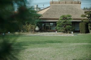 尾道市Ryokan Onomichi Nishiyama的一座带草场的房屋,有一座建筑