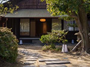 尾道市Ryokan Onomichi Nishiyama的前面有树和走道的房子
