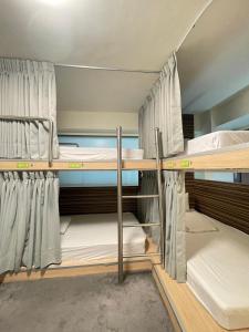 台中市奇异果快捷旅店成功店的宿舍间的两张双层床位 - 带窗帘