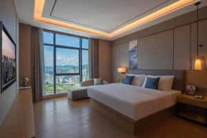 深圳深圳西丽创新谷亚朵酒店的一间卧室设有一张大床和一个大窗户