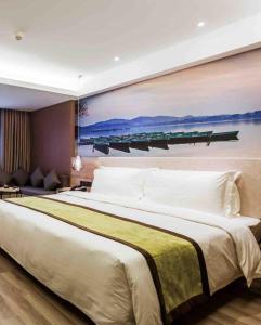 重庆重庆解放碑亚朵酒店的卧室配有一张大床,墙上挂有绘画作品