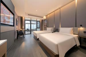 桂林桂林两江四湖象鼻山亚朵酒店的酒店客房设有两张床和电视。