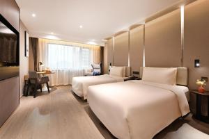 北京北京安贞亚朵S酒店的酒店客房配有两张床和一张书桌