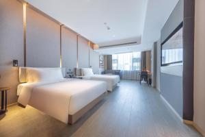 Pin-lien海口高铁东站学院路亚朵酒店的酒店客房配有两张床和一张书桌