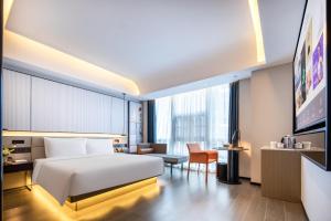深圳Atour S Hotel Shenzhen Futian Port的配有一张床和一把椅子的酒店客房