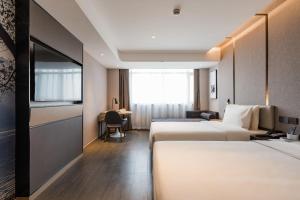 萧山杭州萧山机场亚朵酒店的酒店客房配有两张床和一张书桌