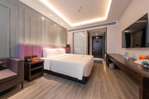 北京北京三元桥地铁站亚朵X酒店的卧室配有一张白色的大床和一张沙发。