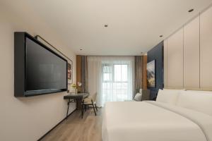 福州福州金山爱琴海亚朵酒店的配有一张床和一台平面电视的酒店客房