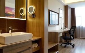 滨海新区天津滨海二大街亚朵酒店的一间带水槽的浴室和一张带椅子的桌子