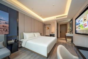 上海上海虹桥莘庄商务区亚朵酒店的卧室配有一张白色大床和一台平面电视。