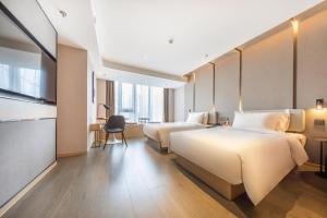 昆明昆明高新吾悦广场亚朵酒店的酒店客房配有两张床和一张书桌