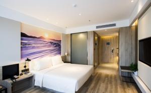 沈阳沈阳浑南奥体中心亚朵酒店的卧室配有一张白色大床和电视。