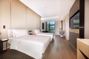 上海上海五角场大学路亚朵酒店的酒店客房设有两张床和电视。