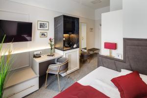 威斯巴登Star-Apart Hansa Hotel的客房设有一张床、一张书桌和电视