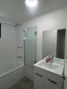 WaterfordYnY Guest house的白色的浴室设有水槽和淋浴。