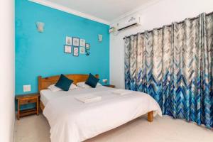 卡兰古特Cerca Del Mar的一间卧室设有两张床和蓝色的墙壁