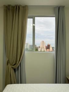 伊塔佩马Apartamento à 390m do Mar的一间卧室设有窗户,享有城市美景