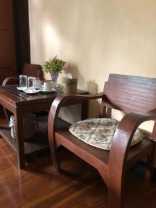 南邦Lampang homestay2的一张带两把椅子的木桌和一张木桌,餐桌上摆放着糕点