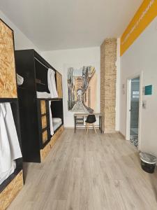 加的斯Planeta Cadiz Hostel的客房设有两张双层床和一张书桌。