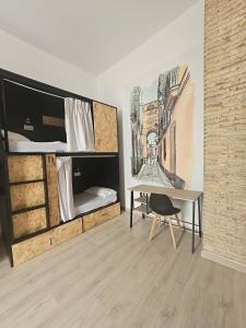 加的斯Planeta Cadiz Hostel的客房设有书桌和双层床。