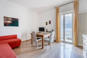 托尔博莱Lake Sensation - Garda Lake View的客厅设有餐桌和红色沙发