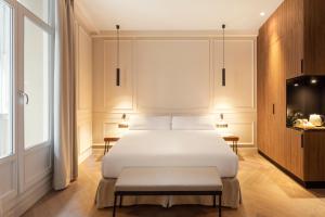 毕尔巴鄂Bilder Boutique Hotel的卧室配有白色的床和电视