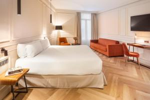 毕尔巴鄂Bilder Boutique Hotel的酒店客房设有一张大床和一张沙发。