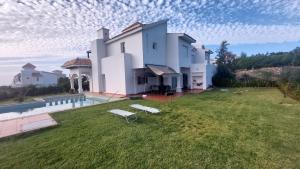 丹吉尔villa star hill Tanger的一座带草坪和游泳池的大型白色房屋