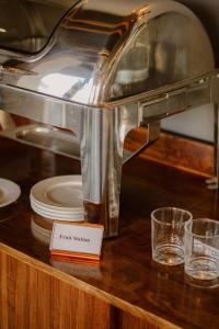 仰光SERENE Stays Hotel的盘子和玻璃杯的柜台上的咖啡机