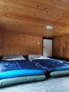 拉瑙The Mountain Camp at Mesilau, Kundasang by PrimaStay的一张位于带木制天花板的客房内的大床