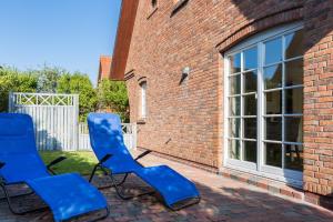 曼克玛肖Heide Hues的两把蓝色椅子坐在砖房外面