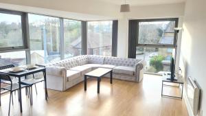 莫利Homestay by BIC Melbourne 14 - LEEDS的客厅配有沙发、桌子和窗户
